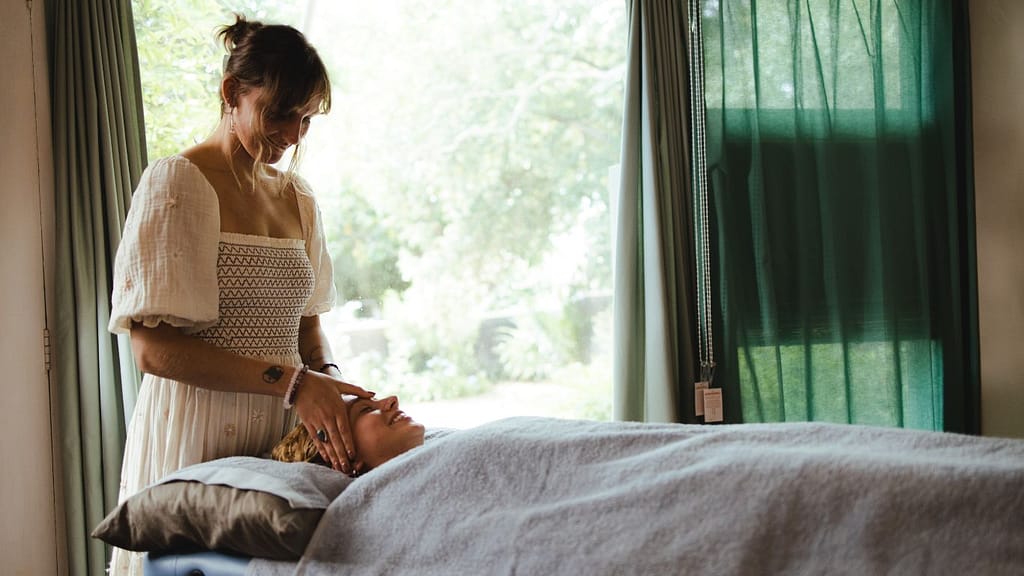 Georgia, a skilled healthcare practitioner, performing a treatment on a person lying on a treatment table.
