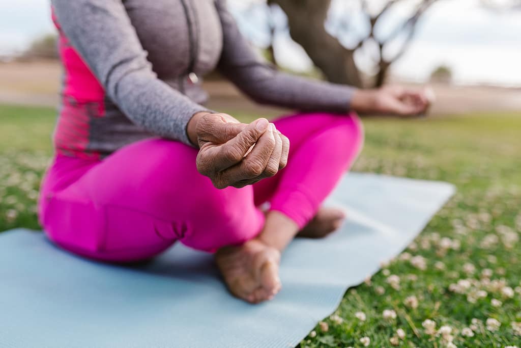 Person practicing yoga in a seated position, with legs crossed and hands resting on knees.
