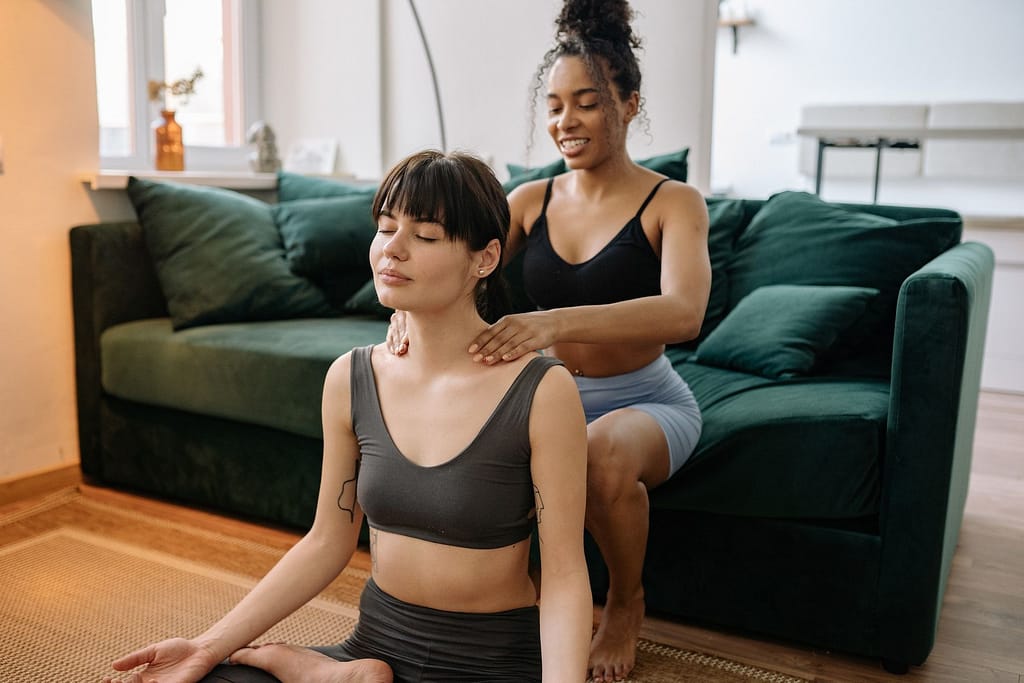 A person giving a massage while sitting on the floor, using skilled techniques to ease tension and promote relaxation in the client.