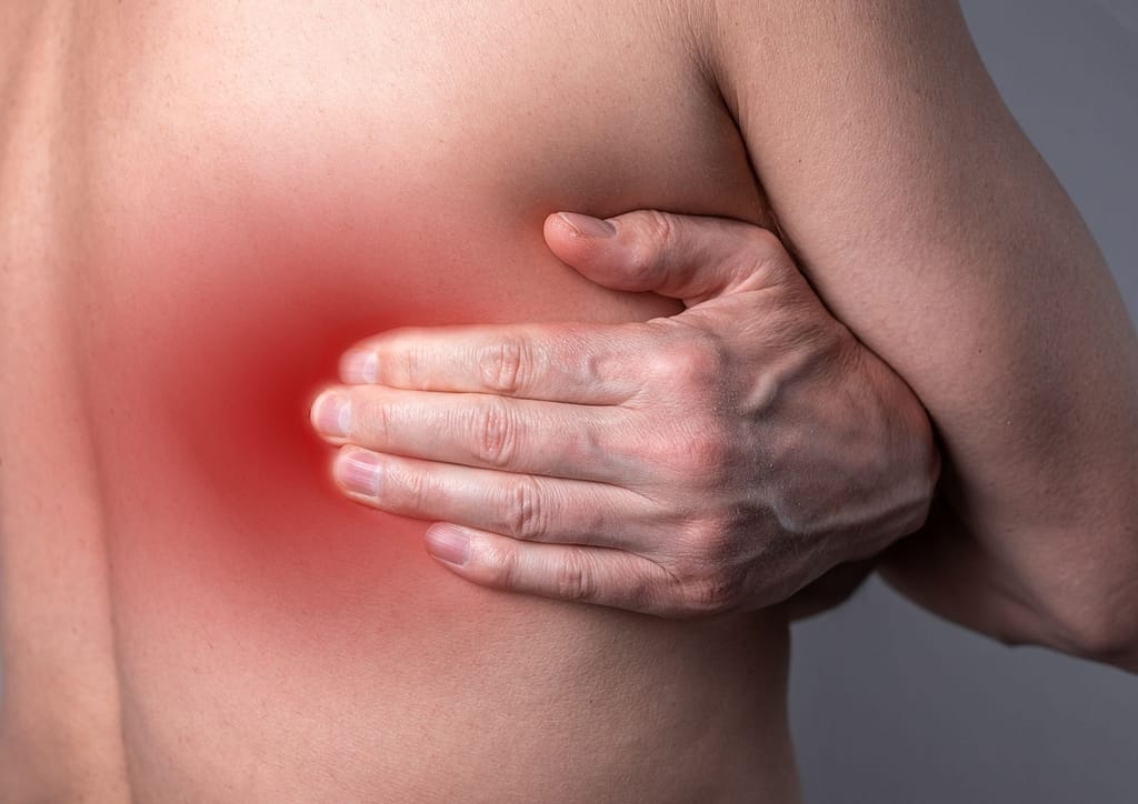 A person applying pressure to a trigger point on their back to relieve muscle tension and discomfort.