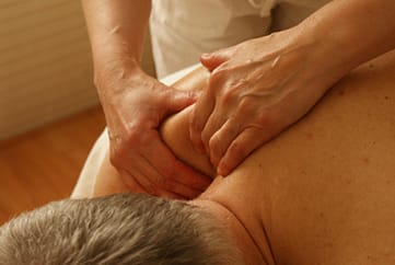Patient receiving remedial massage on a massage table.